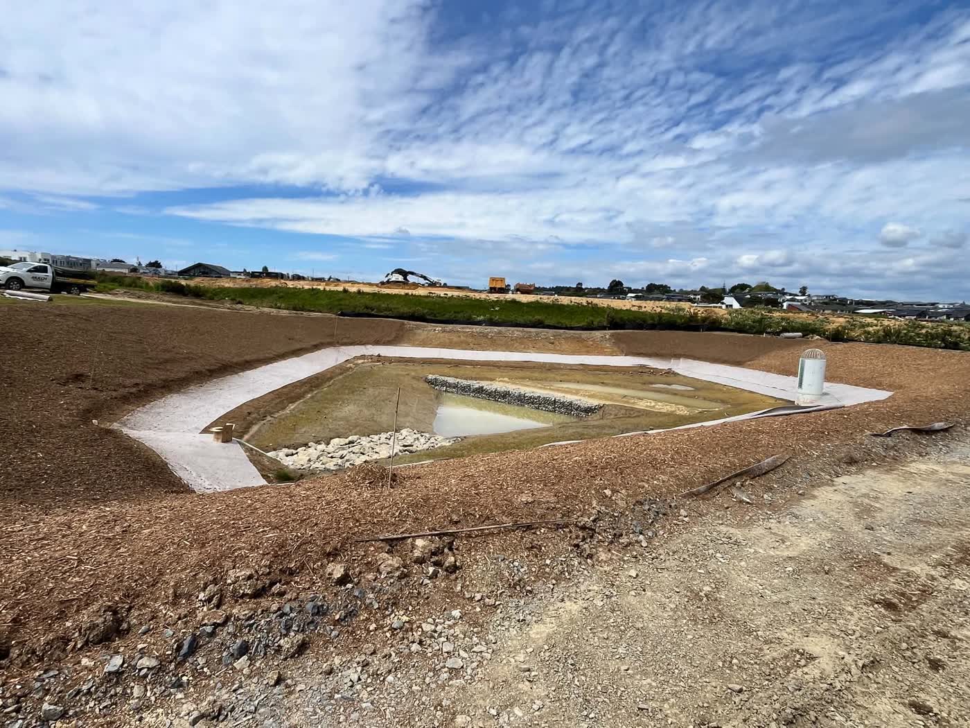 Stormwater retention pond shaped and lined on a subdivision