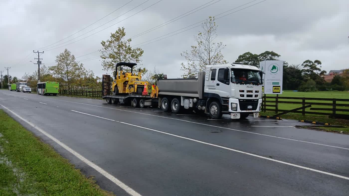 Jai Civil Isuzu 6 wheeler tipper truck with transporter trailer carrying a roller